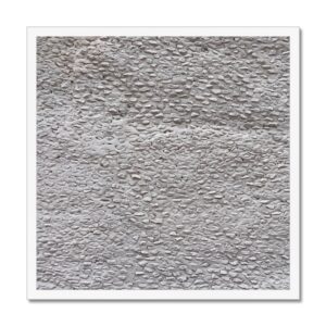 Small stones pressed into whitewashed concrete wall creating an effect of dragon skin.