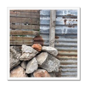 A framed picture of functional wall building materials including wood, metal, and rock.