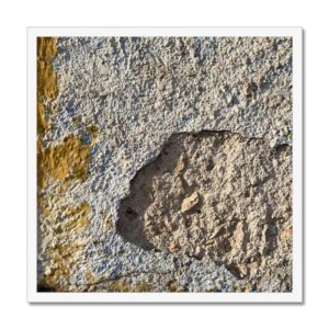 Framed photograph of a broken concrete wall reminiscent of the moon’s surface.