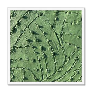 Sage green adobe wall showcasing a whimsical pattern of small stones embedded in sweeping scratch marks.